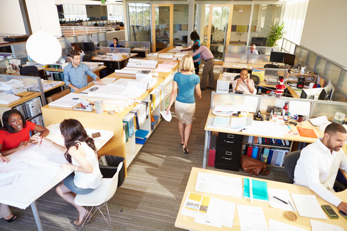 Photo of employees in an office at their desks doing their day to day tasks